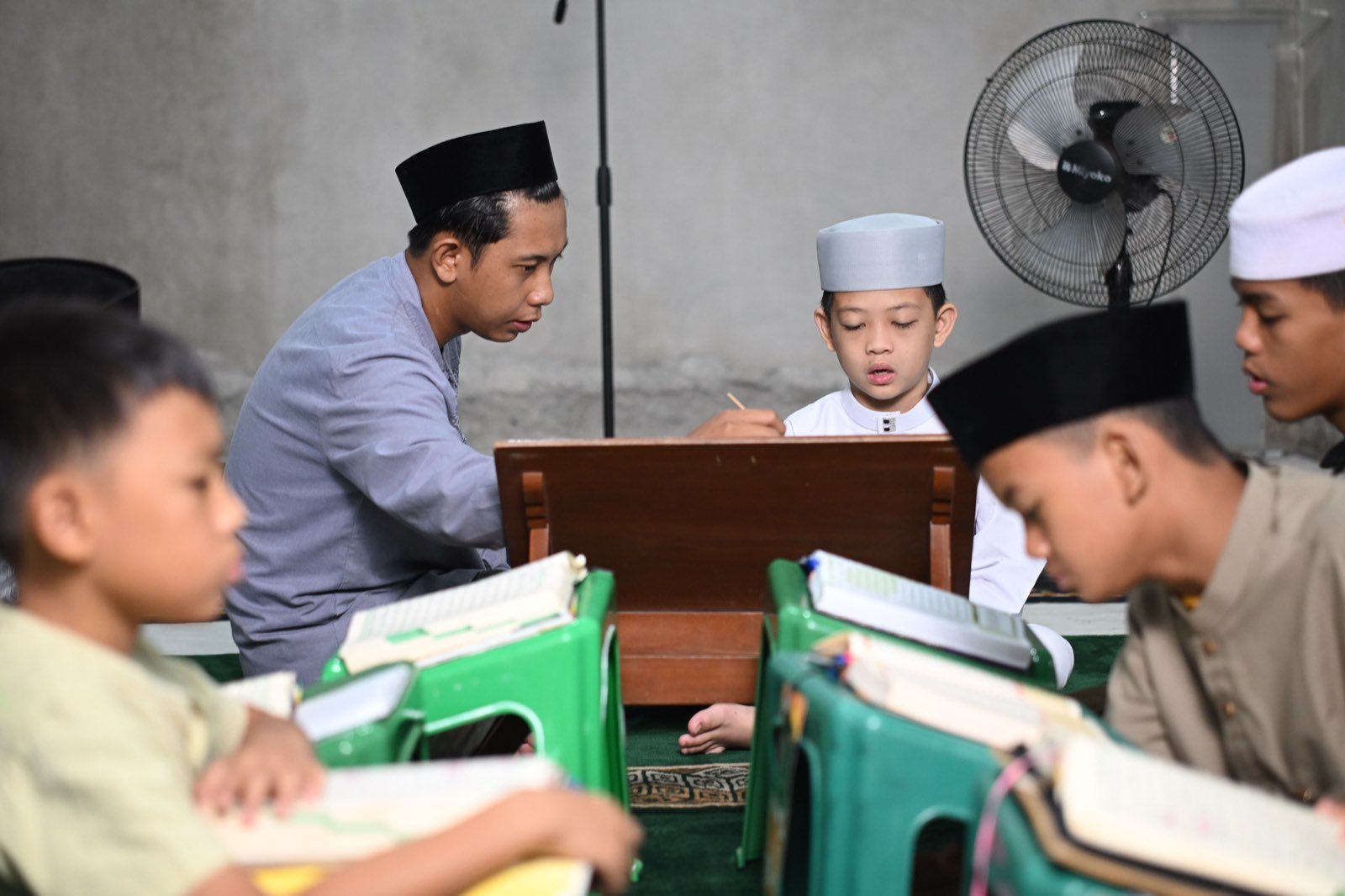 Foto santri sedang menghafal Al-Quran, wajah terlihat jelas